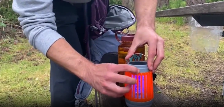 guy placing Buzz Blast Pro in a forest setting
